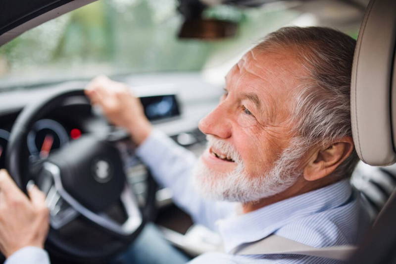Lachende man achter het stuur - Meenemen naar een rijbewijskeuring - Rijbewijsdokter