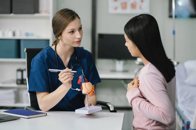 Vrouwelijke doktor die hartklachten behandeld bij Aziatische vrouw | keuringsarts hart en vaatziekten | Rijbewijsdokter